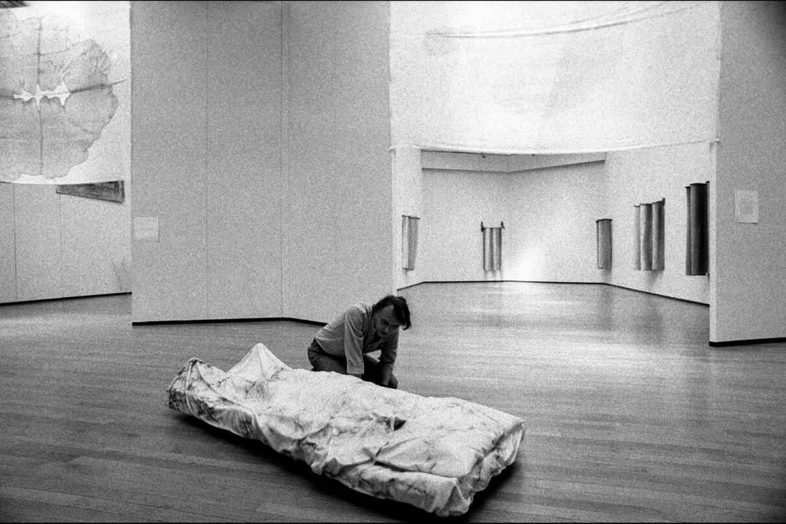 Luciano Fabro con Io rappresento l'ingombro dell'oggetto nella vanità dell'ideologia. Lo Spirato, 1968-73, durante l’allestimento della mostra personale “Letture parallele IV”, PAC Padiglione d’Arte Contemporanea, Milano, 1980 © Archivio Fotografico A. Guidetti e G. Ricci Foto Giovanni Ricci